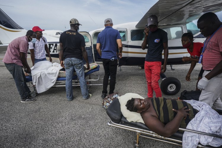 Residents injured by the magnitude-7.2 earthquake are taken on stretchers to a plane that will take them to the capital city of Port-au-Prince, from the airport in Les Cayes, Haiti, on Thursday. 