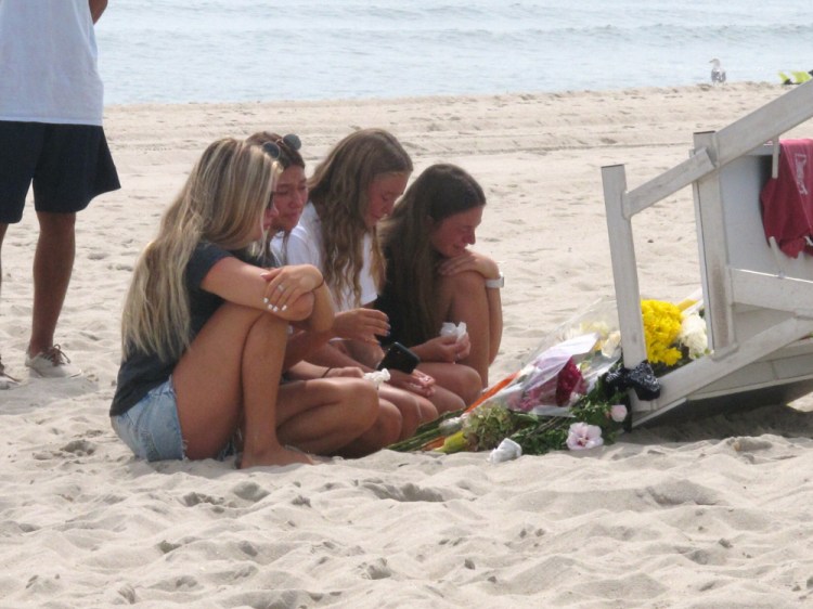 Friends and fellow lifeguards cry at the foot of a lifeguard stand in Berkeley Township, N.J., on Tuesday, a day after 19-year-old lifeguard Keith Pinto was killed by lightning there. Pinto, of Toms River, was among eight people who were hit by lightning Monday afternoon.