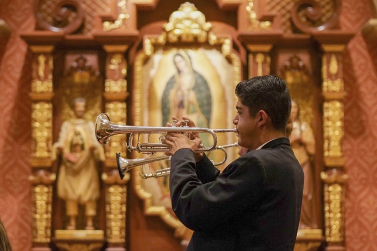 Los Changuitos Feos (Ugly Little Monkeys) mariachi band members Roman Murillo, 14, and Cameron Davison, 18, play their trumpets as they perform during the morning Mass at St. Augustine Cathedral Sunday in downtown Tucson.