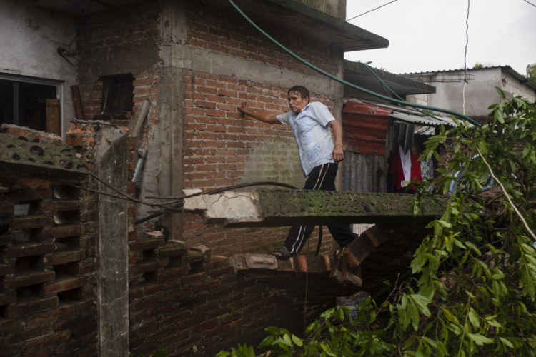 A man inspects the damage Saturday after part of his home was toppled by the winds brought on by Hurricane Grace in Tecolutla, Veracruz State, Mexico.

