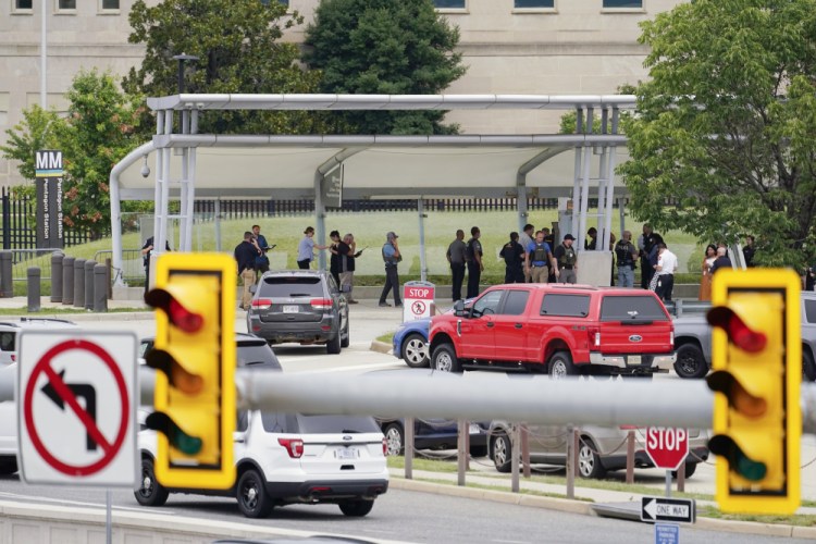 Police gather outside the Pentagon's Metro station Tuesday after the attack that left an officer and the suspect dead. 