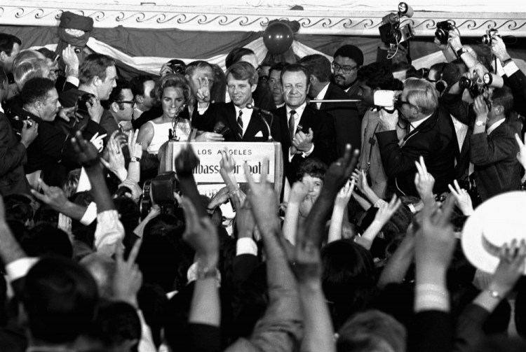 U.S. Sen. Robert F. Kennedy addresses campaign workers moments before being shot in Los Angeles on June 5, 1968. At his side are his wife, Ethel, and his California campaign manager, Jesse Unruh, speaker of the California Assembly.
