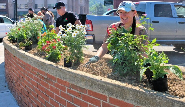 Stephanie Reed, the chair of Rumford’s Beautify Rumford Committee, works with plants in one of the planters that she and committee members prepared for their town beautification project.  