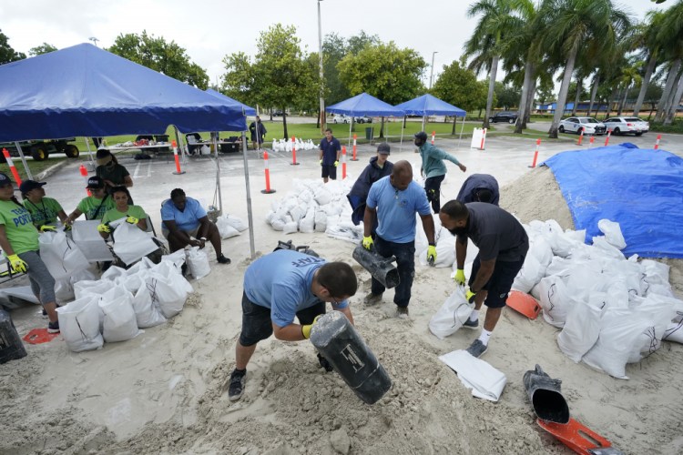 City workers fill sandbags at a drive-thru sandbag distribution event for residents ahead of the arrival of rains associated with tropical depression Fred, Friday, at Grapeland Park in Miami. 