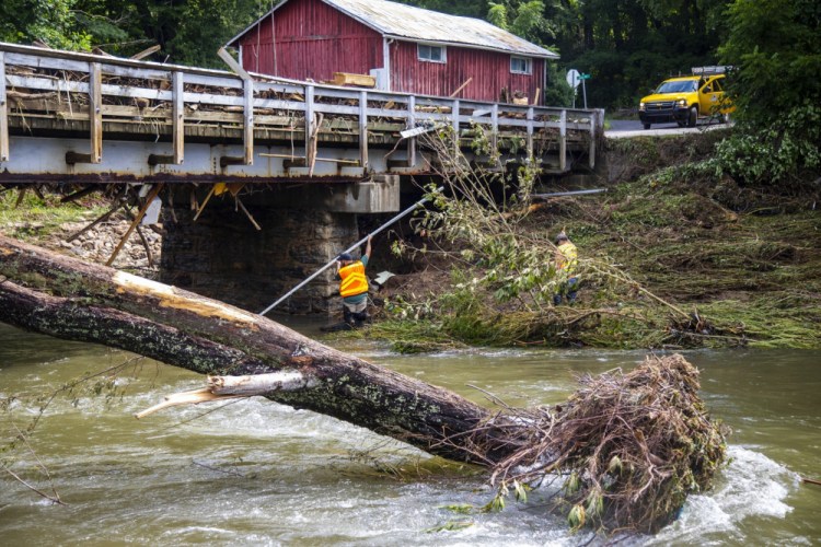 North Carolina highway workers assess damage to a bridge spanning the Pigeon River on Thursday in Bethel, N.C., after remnants from Tropical Storm Fred caused flooding in parts of western North Carolina on Tuesday. Search and rescue teams continue to search the area as 20 people are missing and 2 people were found dead. 