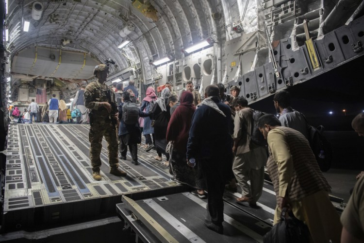 Afghan passengers board a U.S. Air Force C-17 Globemaster III during the Afghanistan evacuation at Hamid Karzai International Airport in Kabul, Afghanistan on Aug. 22. 