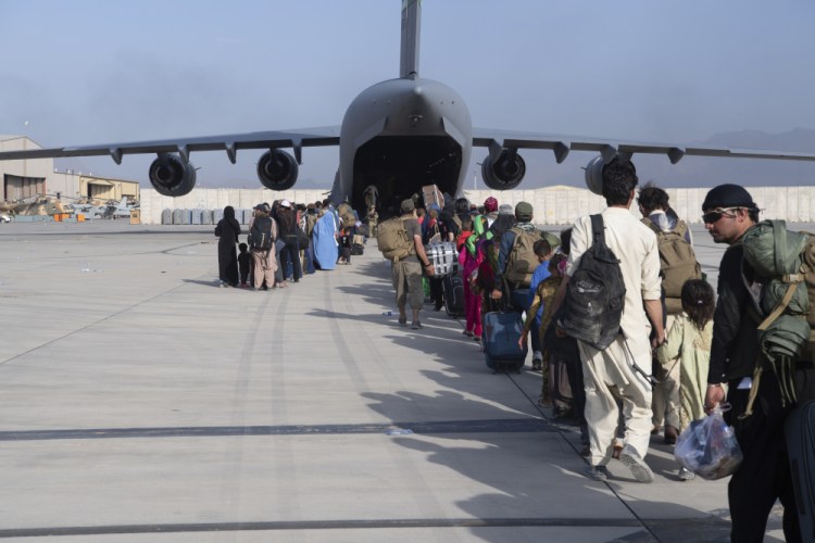 U.S. Air Force loadmasters and pilots assigned to the 816th Expeditionary Airlift Squadron, load evacuees onto a U.S. Air Force C-17 Globemaster III at Hamid Karzai International Airport in Kabul on Tuesday.