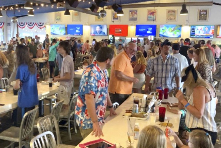 Customers gather and dance inside The Hangout, a popular restaurant in Gulf Shores, Ala., this month. Alabama's coastal counties lead the state in new COVID-19 cases, and some events have been canceled in Florida and Louisiana because of the latest surge. 