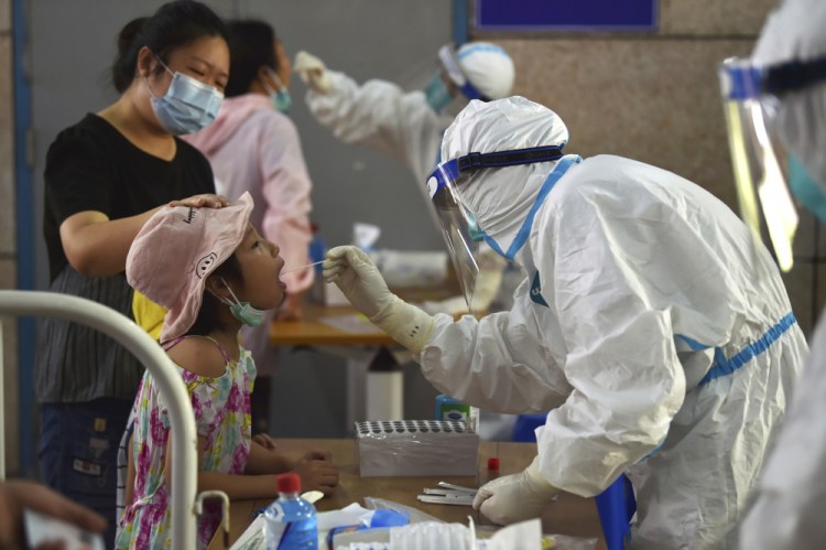 A nurse takes swab samples  in Nanjing in eastern China's Jiangsu province on Monday. 