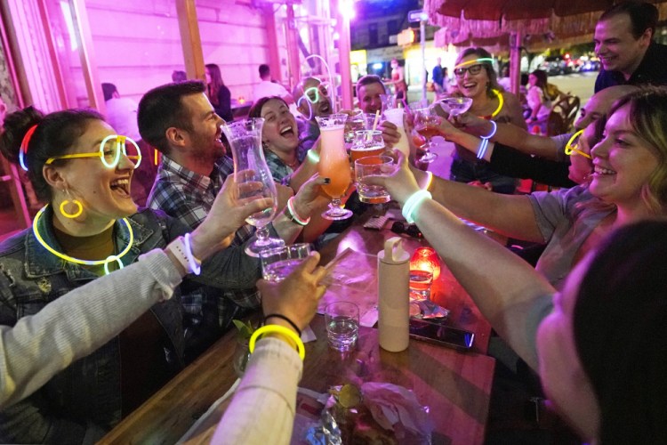  Emily Baumgartner, left, and Luke Finley, second from left, join friends from their church group in a birthday toast to one of the members, upper right, during their weekly "Monday Night Hang" gathering at the Tiki Bar on Manhattan's Upper West Side in May. 
