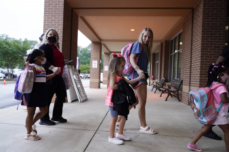 Students and parents walk to class at Tussahaw Elementary school on Wednesday
 in McDonough, Ga.  