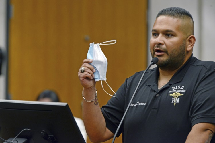 Brownsville Independent School District Director for Health Services Alonso Guerrero, RN, holds up his face mask as he stresses the urgency to mandate the use of face masks before the start of the new school year at all district schools during a district board of trustees special meeting on Thursday in Brownsville, Texas.  