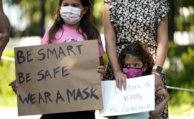 Roxana Weeks, 8, and sister Farah, 4, stand with their family as students and parents gather outside the Governor's Mansion to urge Gov. Greg Abbott to drop his opposition to public school mask mandates, Monday, Aug. 16, in Austin, Texas. 