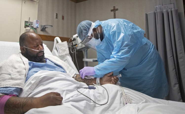 A nurse treats COVID-19 patient Cedric Daniels, 37, of Gonzales, La., at Our Lady of the Lake Regional Medical Center in Baton Rouge, Monday, Aug. 2, 2021. Louisiana is leading the nation in the number of new COVID cases per capita and remains one of the bottom five states in administering vaccinations. 