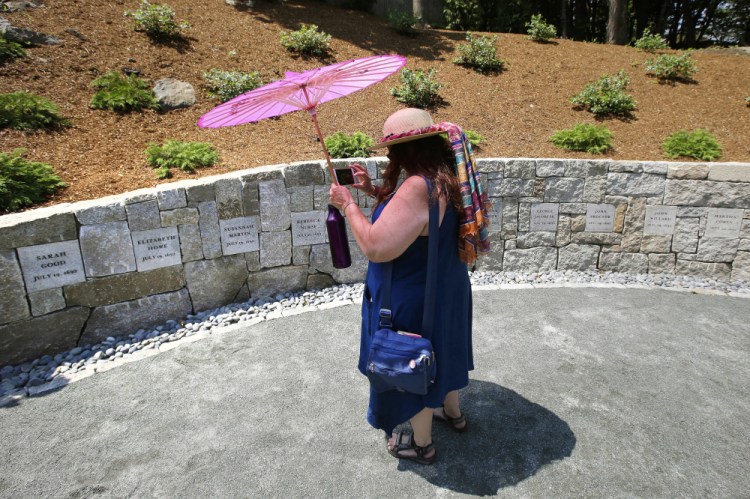 Karla Hailer, a fifth-grade teacher from Scituate, Mass., is shown in 2017 shooting a video where a memorial stands at the site in Salem, Mass., where five women were hanged as witches more than 325 years ago.