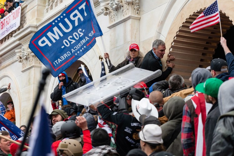 Demonstrators steal a Metropolitan Police riot shield while attempting to enter the U.S. Capitol building in Washington, D.C., on Jan. 6, 2021. 
