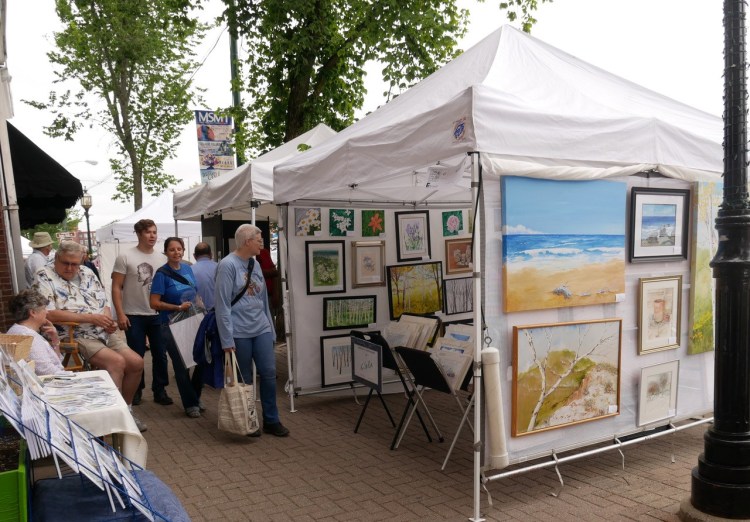 Visitors taking a look at paintings at the arts festival.