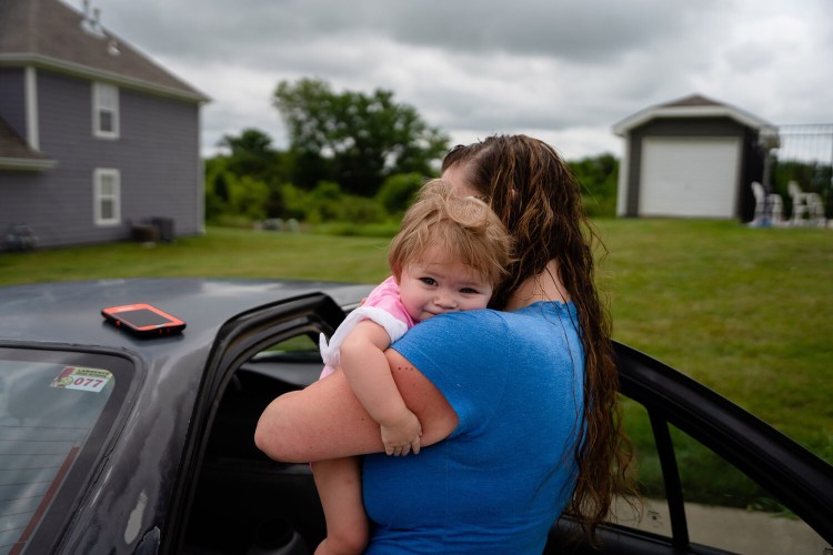 Melissa Markham, a mother of two in Kansas, holds her child, Brooklynn. Markham has lost her home and her job during the coronavirus pandemic, and stringent welfare benefits in the state offer scant relief. MUST CREDIT: Photo for The Washington Post by Christopher Smith