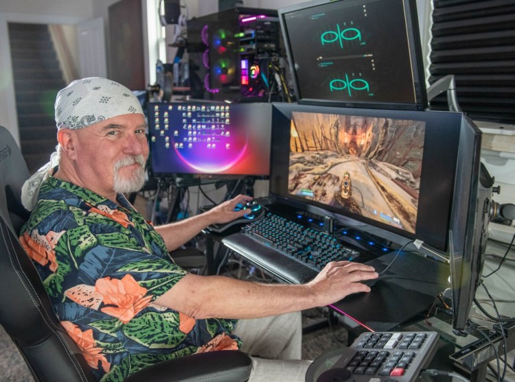Edward Larkin sits at the controls of a video game on Wednesday in his home in Hallowell. Larkin is the inventor of the ALT Avatar Motion Controller and the CEO of PLA LABS LLC.  He uses the controller to play video games, but says it can be prgrammed to do many things a keyboard can do.