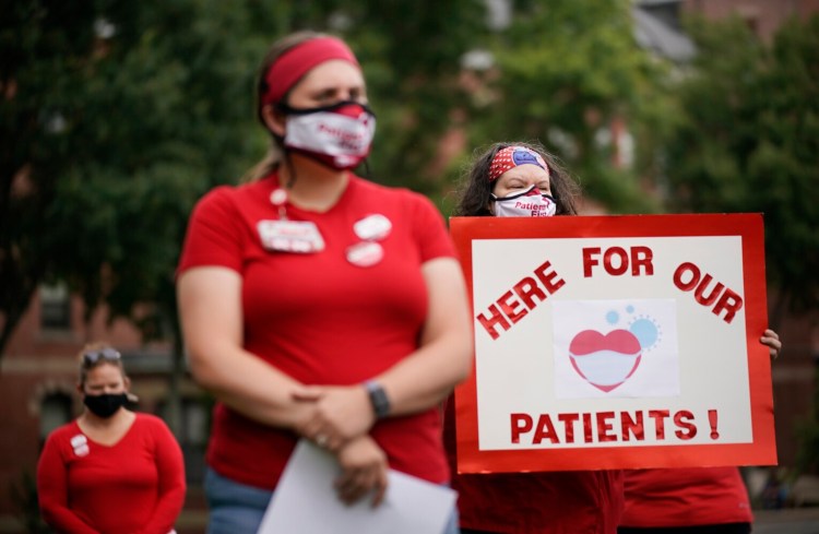 PORTLAND, ME - SEPTEMBER 1: Janel Crowley, a nurse at Maine Medical Center, holds a sign during a press conference organized by the hospital’s nurses union on Wednesday. Members of the nurses union called on the hospital to not cancel pandemic protections the hospital put in place last year. Specifically, the nurses want the hospital to allow high risk employees to work alternative assignments, to continue to pay for the cost of treatment for employees who contract COVID-19, to provide quarantine pay to employees exposed to the virus outside of the hospital and providing paid time off for workers who are past 37-weeks of pregnancy. (Staff photo by Gregory Rec/Staff Photographer)