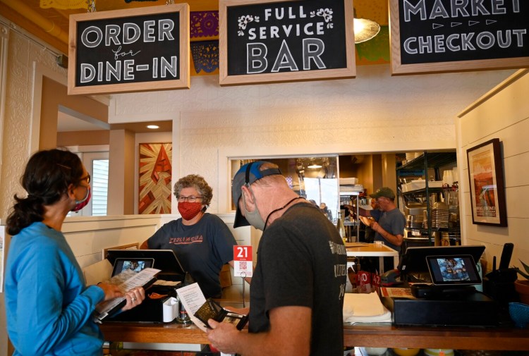 PORTLAND, ME - SEPTEMBER 2: Dee Ramonas talks with customers looking over the menu at the counter at Terlingua in Portland Thursday, September 2, 2021. (Staff Photo by Shawn Patrick Ouellette/Staff Photographer)
