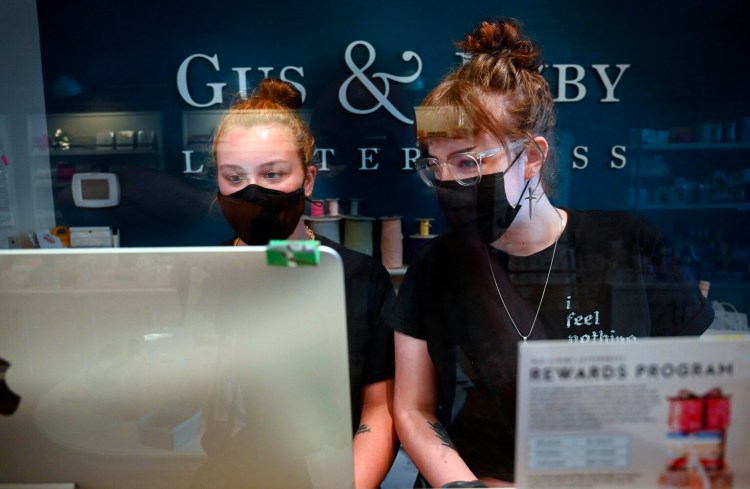 PORTLAND, ME - SEPTEMBER 13: Ellie Cania, left and Tori Shoemaker work behind the counter at Guss & Ruby Letterpress in Portland Friday, September 13, 2021. Portland City Council is voting tonight on implementing an indoor mask mandate for the city. (Staff Photo by Shawn Patrick Ouellette/Staff Photographer)
