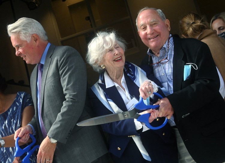 Financial donors Peter H. Lunder, right, and wife Paula Crane Lunder share a fun moment Tuesday during the ribbon-cutting for the Greene Block + Studios. The Lunders donated $3 million dollars toward the project. At left is Colby College President David Greene.