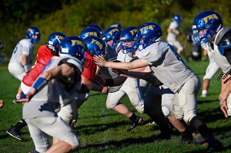 Members of the Falmouth High football team run a drill during practice on Thursday. Maine high school teams, including Falmouth football, have been struggling to get their games in this season because of COVID-19 issues.