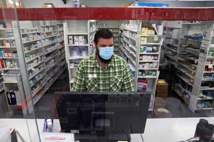 Justin Richards, a pharmacist at Community Pharmacy of Saco, works behind the counter on Thursday. He said the store receives just 12 packages of Abbott Laboratories' BinaxNOW COVID-19 Ag Card Home Tests per week, and they sell out quickly. "It's a big bummer because everybody's looking for one," he said.