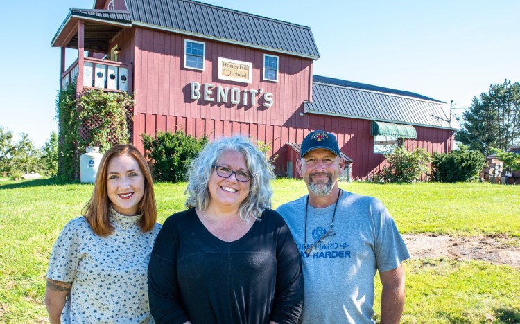 Jennifer Dolloff Barker, middle, husband Jeff Barker, right, and daughter Holly Lavorgna, left, stand Sunday outside the store owned by her son, Sabin Lavorgna, at Honey Hill Orchard on Ferry Road in Lewiston where the former Benoit's Orchard was located.