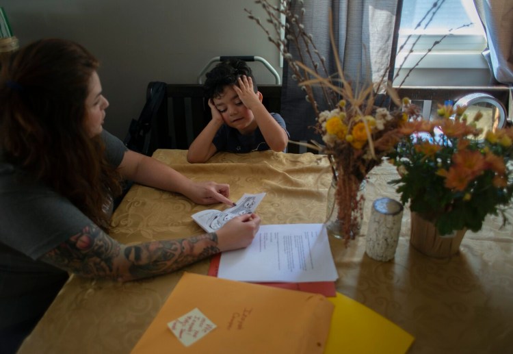 GORHAM, ME - SEPTEMBER 20: Christen Cowper does homework with her son, Izayah, 5, who is in quarantine at home because he was exposed to COVID at school. He has medical conditions that make him more susceptible to severe illness should he catch COVID.. (Photo by Derek Davis/Staff Photographer)