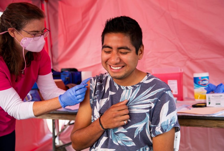 CUMBERLAND, ME - SEPTEMBER 30: Maine CDC administered a vaccination clinic on Thursday at the Cumberland County Fair. Jessica McCurdy gives a Johnson & Johnson shot to Victor Garcia, 24, of Pittsfield, MA at the clinic on Thursday. (Photo by Derek Davis/Staff Photographer)
