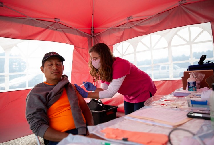 CUMBERLAND, ME - SEPTEMBER 30: Maine CDC administered a vaccination clinic on Thursday at the Cumberland County Fair. Jessica McCurdy gives a Johnson & Johnson shot to Galindo Garcia, a fair worker from Pittsfield, MA. (Photo by Derek Davis/Staff Photographer)