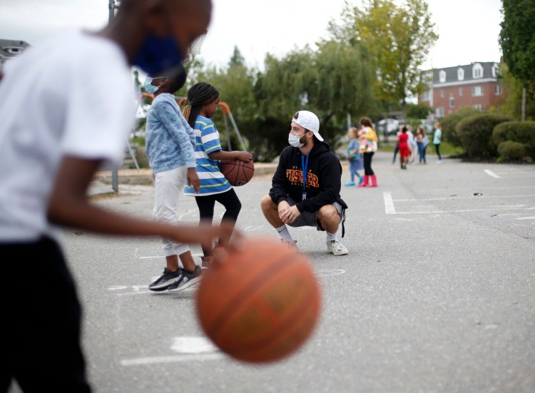 Nick Daniello, a recreation programmer for the city of Portland, plays with children at the East End Community School during an after-school program Tuesday.