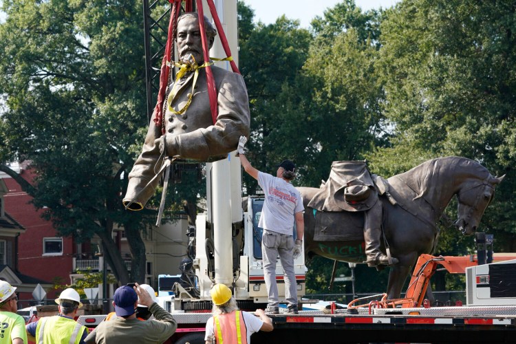 Crews gently lower the torso of Confederate General Robert E. Lee, one of the country's largest remaining monuments to the Confederacy, on Monument Avenue in Richmond, Va., Wednesday, Sept. 8, 2021. (AP Photo/Steve Helber)