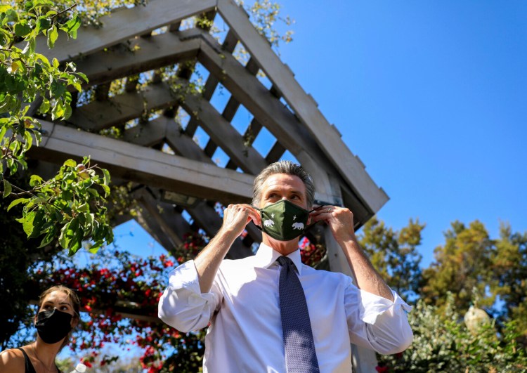 California Gov. Gavin Newsom adjusts his face mask during a rally at St. Mary's Center in Oakland, Calif., Saturday, Sept. 11, 2021. The last day to vote in the recall election is Tuesday, Sept. 14. A majority of voters must mark "no" on the recall to keep Newsom in office. (Shae Hammond/Bay Area News Group via AP)