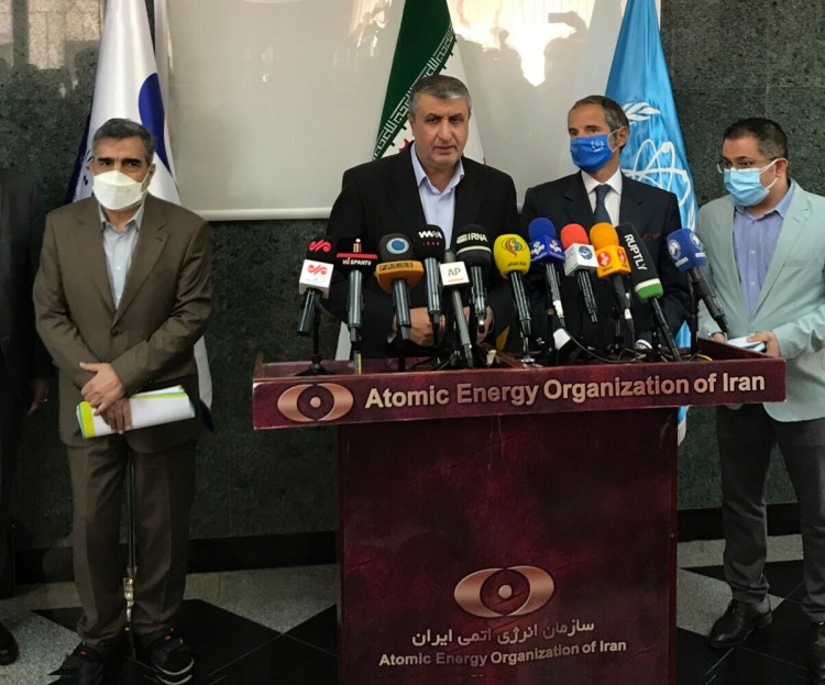 Head of Atomic Energy Organization of Iran, Mohammad Eslami, center, speaks during a joint press briefing with Director General of International Atomic Energy Agency, IAEA, Rafael Mariano Grossi, second right, in Tehran, Iran, Sunday, Sept. 12, 2021. Iran agreed Sunday to allow international inspectors to install new memory cards into surveillance cameras at its sensitive nuclear sites and to continue filming there, averting a diplomatic showdown this week. (Atomic Energy Organization of Iran via AP)