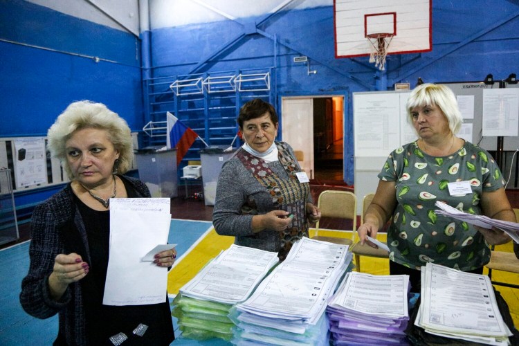 Members of an election commission prepares to count ballots after voting at a polling station after the Parliamentary elections in Nikolayevka village outside Omsk, Russia, Sunday, Sept. 19, 2021. From the Baltic Sea to the Pacific Ocean, Russians across eleven time zones voted Sunday on the third and final day of a national election for a new parliament, a ballot in which the pro-Kremlin ruling party is largely expected to retain its majority after months of relentless crackdown on the opposition. (AP Photo/Evgeniy Sofiychuk)