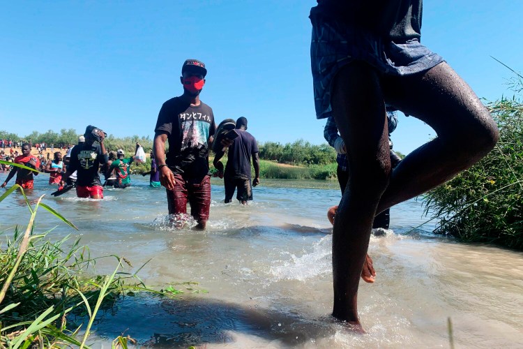 Migrants find an alternate place to cross between Mexico and the United States after access to a dam was closed, Sunday, Sept. 19, 2021, in Ciudad Acuña, Mexico. U.S. officials said that within the next few days, they plan to ramp up expulsion flights for some of the thousands of Haitian migrants who have gathered in the Texas city from across the border in Mexico. (AP Photo/Sarah Blake Morgan)