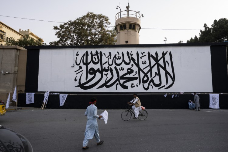 The iconic Taliban flag is painted on a wall outside the American embassy compound Saturday in Kabul, Afghanistan.