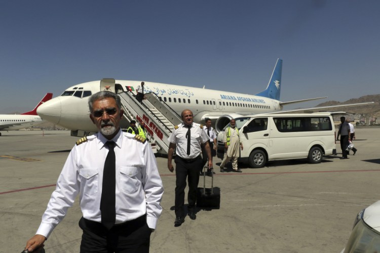 Pilots of Ariana Afghan Airlines walk on the tarmac after landing at Hamid Karzai International Airport in Kabul, Afghanistan, on Sunday.

