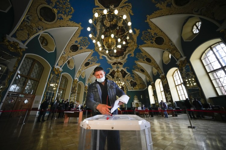 A man casts his ballot at a polling station at the Kazansky railway station during the Parliamentary elections in Moscow, Russia, Saturday, Sept. 18.  