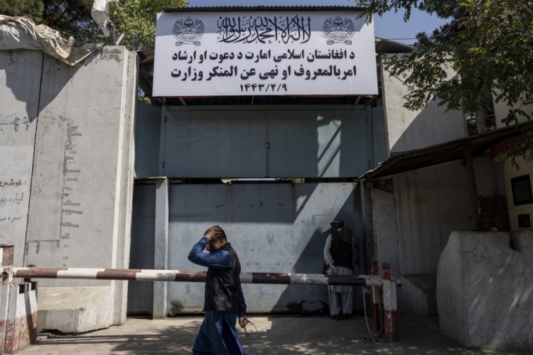 An Afghan man walks past the former Women's Affairs Ministry building in Kabul, Afghanistan, on Saturday. Afghanistan's new Taliban rulers set up a ministry for the "propagation of virtue and the prevention of vice" in the building. (AP Photo/Bernat Armangue)
