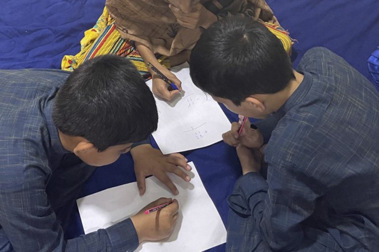 Three children amuse themselves in their Afghanistan "prison-home," in this picture provided by their mother. Every night, their father, a U.S. green card holder from California, and his wife take turns sleeping, with one always awake to watch over the children so they can flee if they hear the footsteps of the Taliban. (AP Photo)