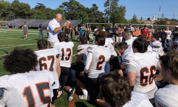 Biddeford Coach Steve Allosso gets emotional as he talks to his team Saturday after they awarded him the game ball following a 36-14 win at Deering. It was Allosso’s first game as the Tigers’ head coach.