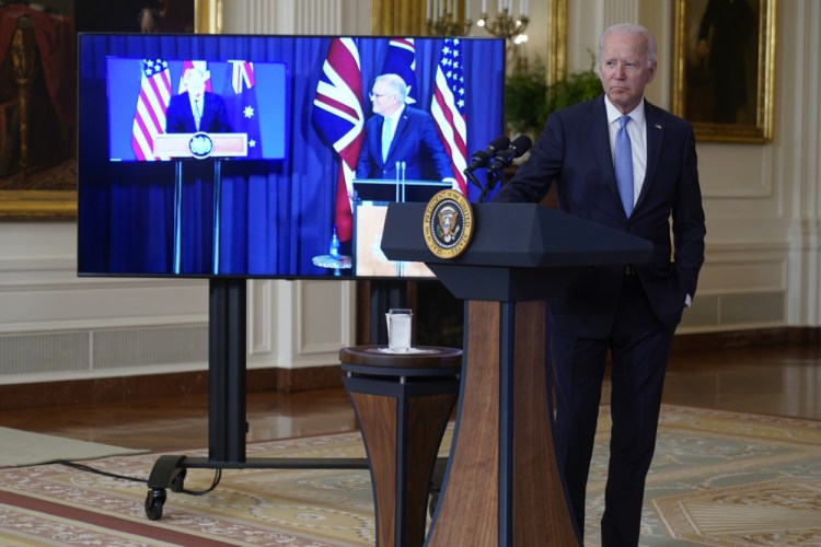 President Joe Biden, joined virtually by Australian Prime Minister Scott Morrison, right on screen, and British Prime Minister Boris Johnson, speaks about a national security initiative from the East Room of the White House in Washington on Wednesday. 