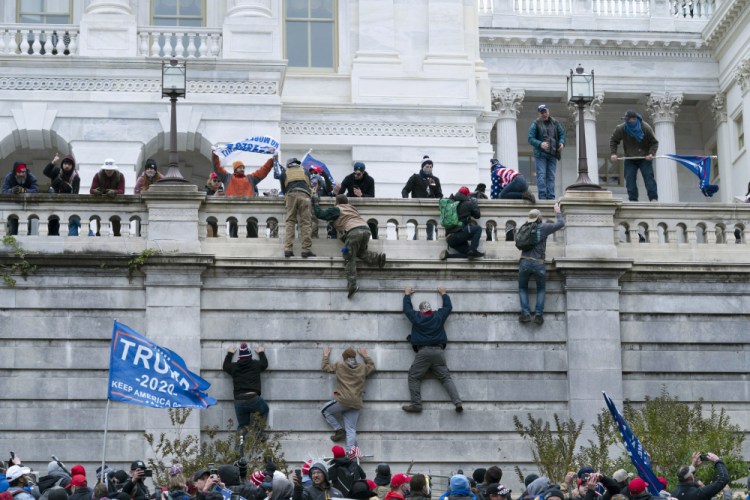 Violent insurrectionists loyal to President Donald Trump scale the west wall of the the U.S. Capitol in Washington on Jan. 6.

