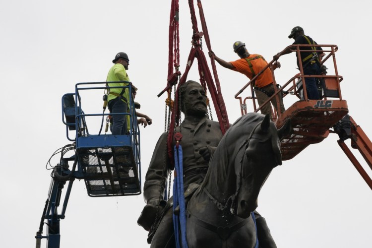 Crews work to remove one of the country's largest remaining monuments to the Confederacy, a towering statue of Confederate General Robert E. Lee on Monument Avenue, Wednesday, Sept. 8, 2021, in Richmond, Va. 