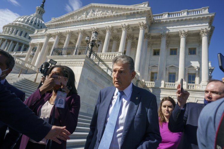 Sen. Joe Manchin, D-W.Va., a centrist Democrat vital to the fate of President Biden's $3.5 trillion domestic agenda, is surrounded by reporters outside the Capitol in Washington on Wednesday. 