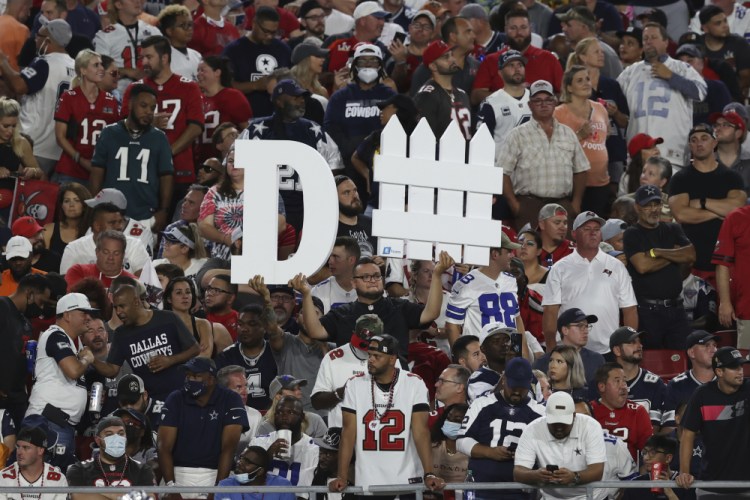 A Tampa Bay Buccaneers fan holds a sign during the first half of an NFL football game against the Dallas Cowboys Thursday in Tampa, Fla. (AP Photo/Mark LoMoglio)